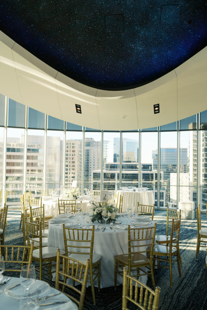 Modern indoor wedding reception space with city skyline views