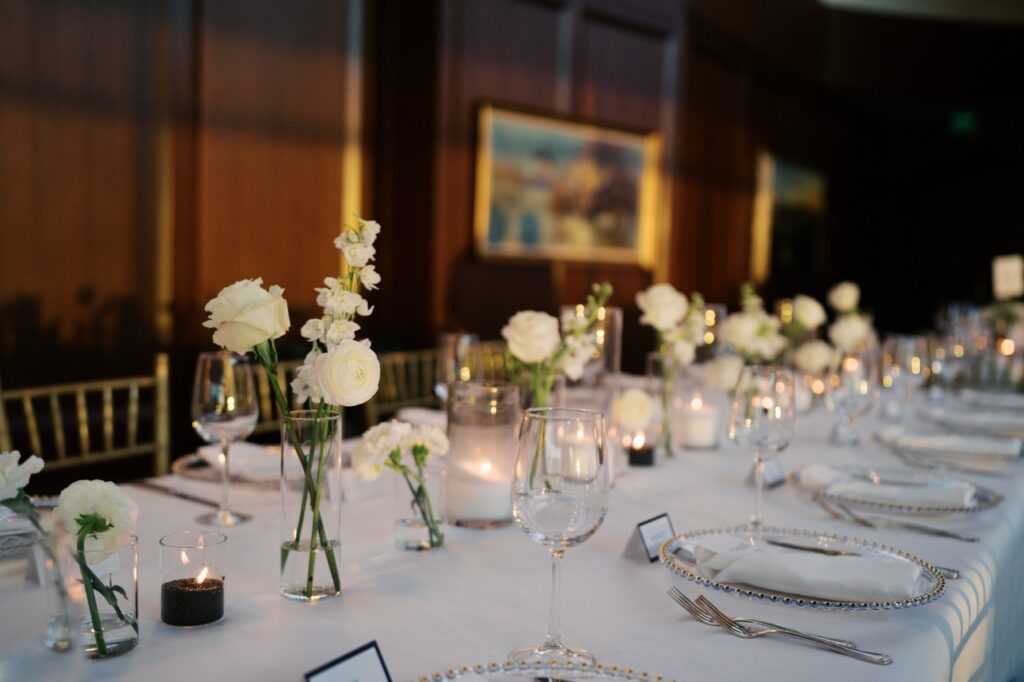 Elegant wedding reception table with floral centerpieces, candles, and place settings