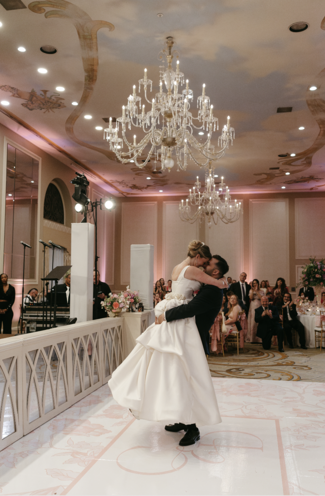 Bride and groom dancing under chandeliers at The Adolphus in Dallas