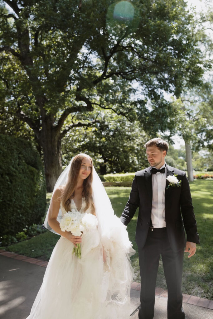 Bride and groom walking through Dallas Arboretum