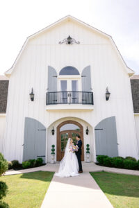 Bride and groom posing in front of The French Farmhouse