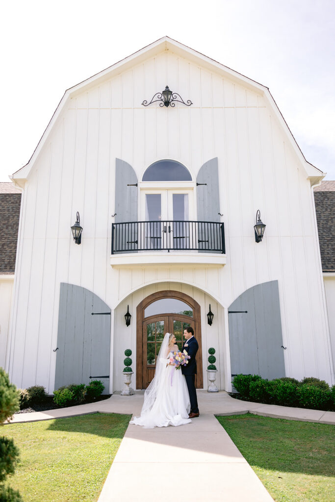Bride and groom posing in front of The French Farmhouse