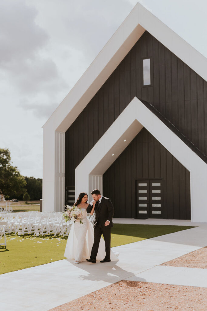 Bride and groom walking in front of building at Honey Creek Venues