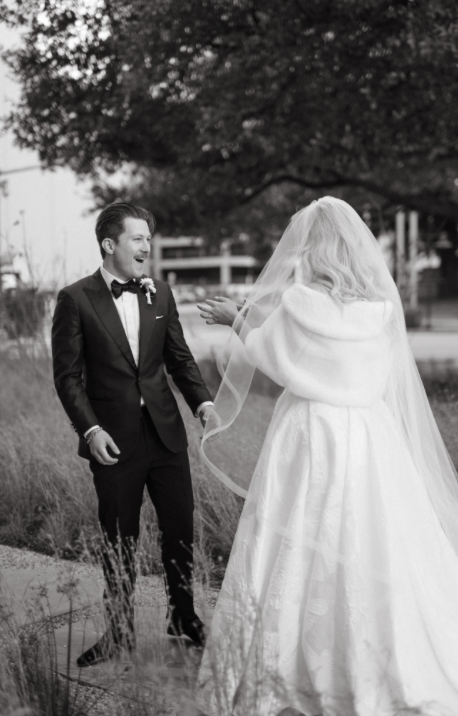 Black and white bride and groom first look in Dallas wearing a tuxedo and white fur shawl
