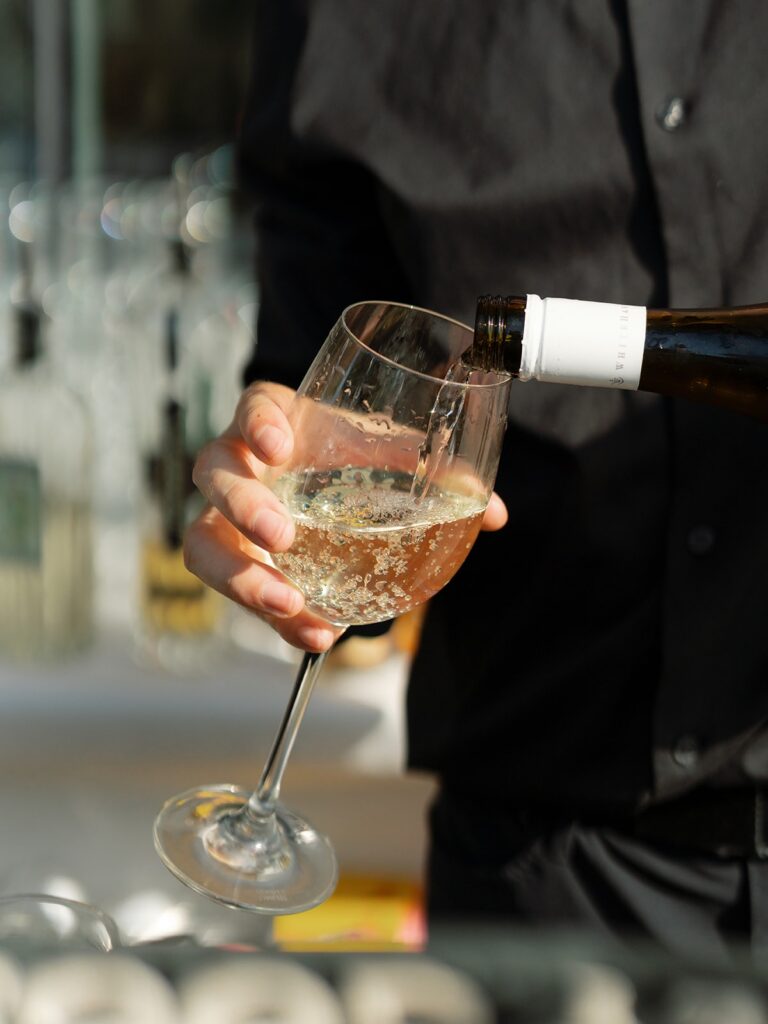 Waiter in black shirt pouring champagne